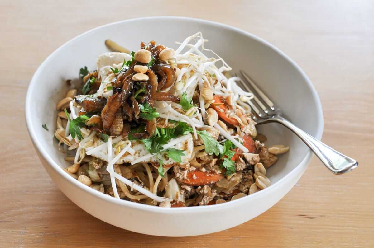 White bowl of homemade vegetarian pad Thai with a silver fork